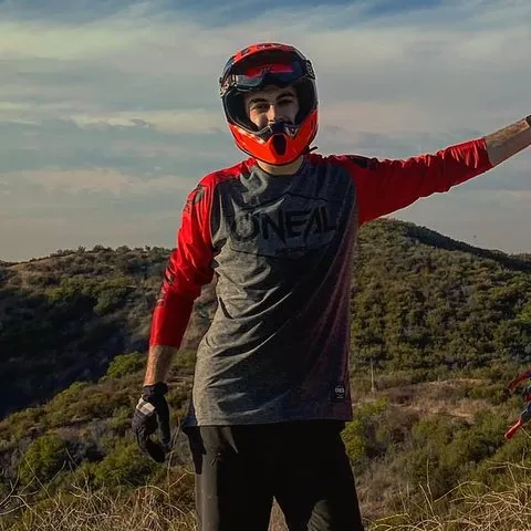 Josh in a mountain bike helmet on a ridge